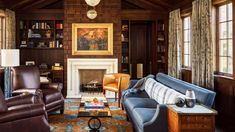 a living room with couches, chairs and a fire place in the middle of it