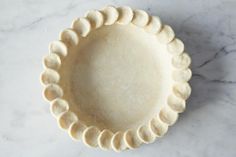 an uncooked pie crust on a marble countertop