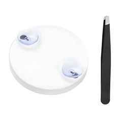 two toothbrushes are next to a white plate with black handles and one is empty