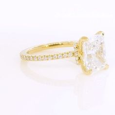 a yellow gold ring with a princess cut diamond