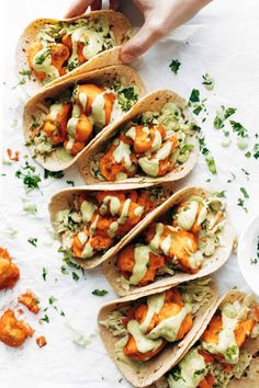 four tacos with chicken, avocado and cilantro sauce on them