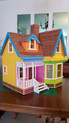 a paper doll house sitting on top of a wooden table