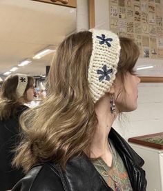 a woman wearing a white knitted hat with blue flowers on the front and side