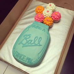 a decorated cake in the shape of a mason jar with flowers on top and saying'having a ball since july '