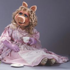 a large stuffed animal sitting on top of a table next to a cup and saucer