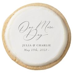 a cookie with the words one more day written on it and an image of a couple's initials