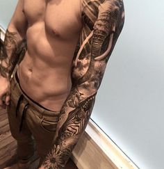 a man with tattoos on his arm and chest standing in front of a bathroom mirror