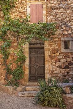 an old stone building with a wooden door and steps leading up to the front door