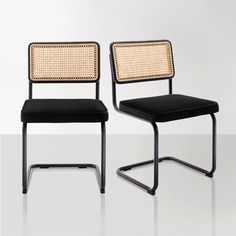 two black chairs with woven back and seat cushions