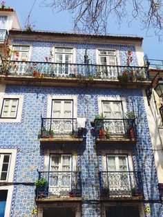 an apartment building with blue and white tiles on it's sides, windows and balconies