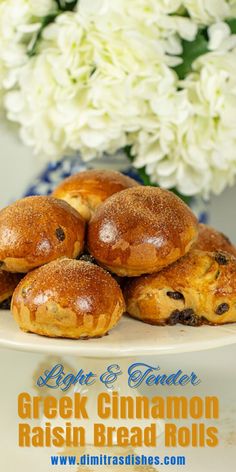 there are some bread rolls on the plate and flowers in the background with text overlay that reads light & tender greek cinnamon raisin bread rolls