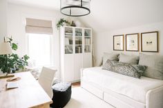 a living room filled with furniture and a white couch next to a wooden dining table