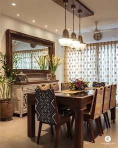 a dining room table with chairs and a mirror