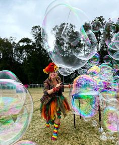 a woman is walking through soap bubbles in the grass with her head turned to look like a clown