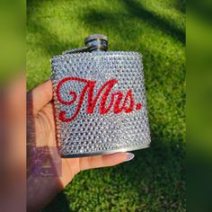 a person holding a flask with the word was written on it in red ink