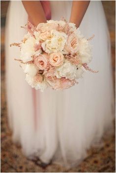 the bride is holding her wedding bouquet