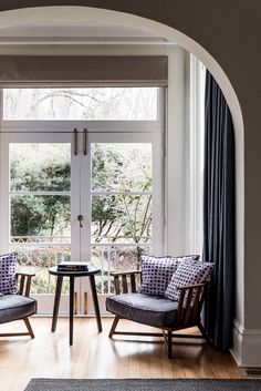 two chairs sitting next to each other in front of a window