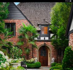 a house with lots of plants and trees in front of the entrance to the building