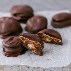 chocolate covered cookies sitting on top of a piece of parchment paper next to each other