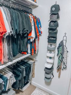 a closet filled with lots of different types of shirts and hats hanging on the wall