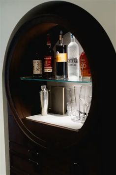 a shelf with liquor bottles and glasses on it