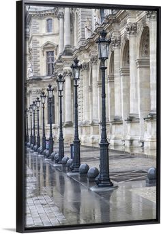 a row of street lamps sitting on the side of a building