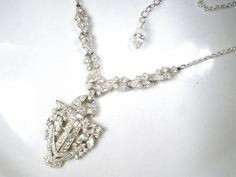 "Offering a gorgeous antique 1920's - 1930's era Art Deco French paste pave rhinestone Flapper pendant lavaliere necklace perfect for the Bride! I absolutely adore this necklace! The SO Art Deco ornate geometric shaped shiny silver pot metal pendant is lavishly encrusted with marquise and baguette cut as well as small round cut closely pave set brilliantly clear sparkly crystal rhinestones. The pendant hangs from ornate links that compliment the pendant so well and are adorned with more clear sp Antique Crystal Wedding Necklaces, Antique Crystal Necklaces For Wedding, Antique Bridal Necklace With 17 Jewels For Wedding, Art Deco Crystal Necklace For Wedding, Victorian Wedding Jewelry With Rhinestones, Art Deco Rhinestone Jewelry For Wedding, Art Deco Wedding Jewelry With Rhinestones, Flapper 1920s, 20s Wedding