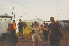 a group of people standing next to each other in front of tents with flags on them