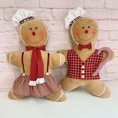 two gingerbread man and woman dolls sitting next to each other