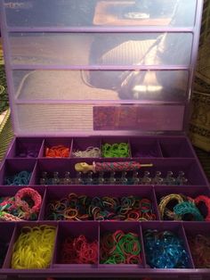 an open purple box filled with lots of different colored bracelets and beads in it