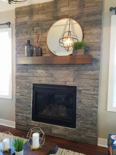 a living room with a fire place and a mirror on the wall above it's mantle