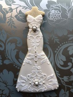 a white wedding dress ornament hanging on a wall