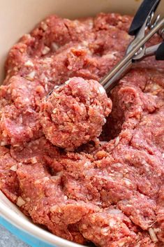 a bowl filled with meatballs next to a fork