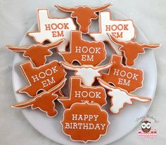 decorated cookies are arranged on a plate with the words hoof em, hook em and happy birthday