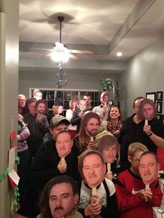 a group of people standing around each other in a room with christmas decorations on the walls