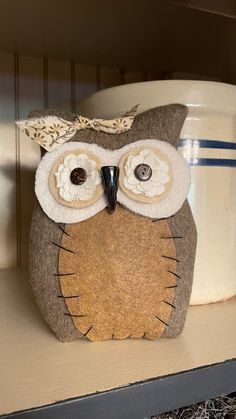 an owl stuffed animal sitting on top of a shelf