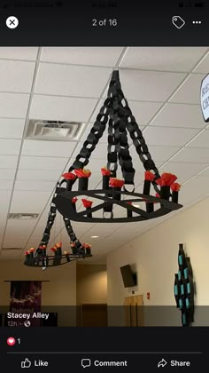 a chandelier hanging from the ceiling in an office building with red candles on it