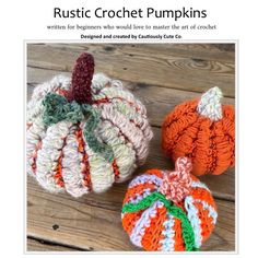 three crocheted pumpkins sitting on top of a wooden table