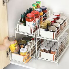 an organized pantry drawer with canned food and condiments on the bottom shelf for storage