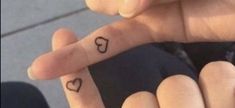 two hearts tattooed on the fingers of someone's left and right thumbnails