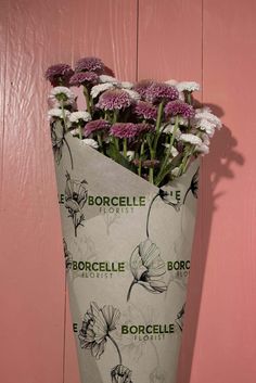 a bouquet of flowers sitting in a vase against a pink wall