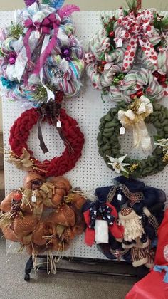 several wreaths are hanging on the wall next to each other in front of a sign