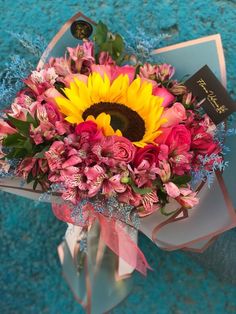 a bouquet of pink and yellow flowers in a vase