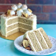 a slice of cake with white frosting and bananas on top sits next to the rest of the cake