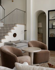 a living room filled with furniture and a spiral staircase