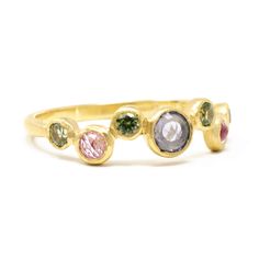 three different colored stones on a gold band