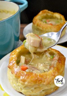 a spoon scooping soup out of a pot pie on top of a white plate