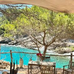 an outdoor dining area with table and chairs next to the water's blue lagoon