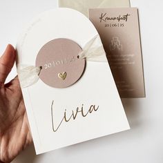 a hand holding a card with the word livva written on it and a tag attached to it