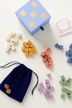 an assortment of wooden dices in a blue gift bag next to it's contents